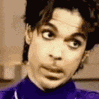 a close up of a man 's face with a purple shirt on making a funny face .