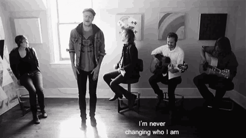 a group of people singing and playing guitars with the words i 'm never changing who i am on the bottom