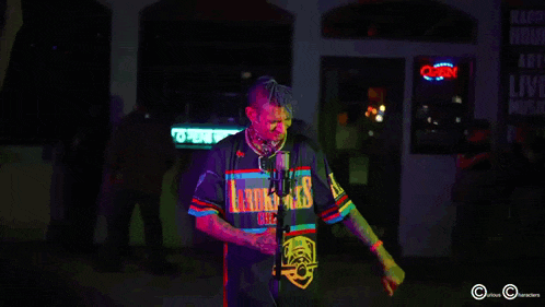 a man stands in front of a neon sign that says open