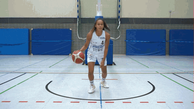 a female basketball player wearing a white jersey with the number 4 on it