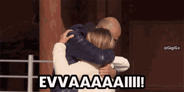 a man is hugging a woman with the words evvaaaa written on the screen