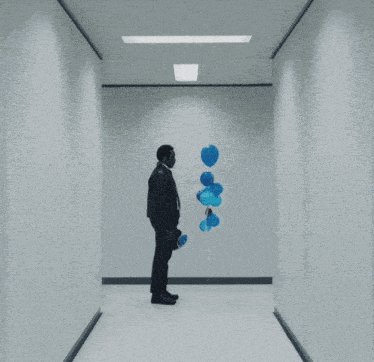 a man is holding a bunch of blue balloons