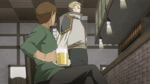 a man in a green shirt holds a beer mug while another man stands behind him