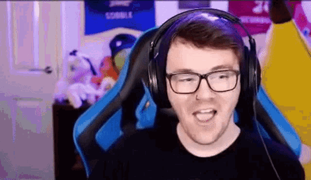 a man wearing glasses and headphones is sitting in a blue chair