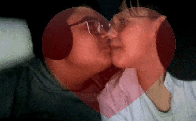 a man and woman kissing with a heart in the background