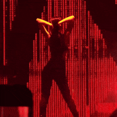 a woman is dancing in front of a red background that says ' a ' on it