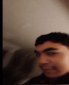 a blurry picture of a man 's face with a white wall behind him