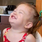 a little girl in a red tank top is laughing with her eyes closed
