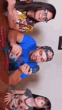 a group of people are sitting at a table playing a game with a remote control .