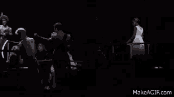 a man and a woman are standing next to each other on a stage in a dark room .