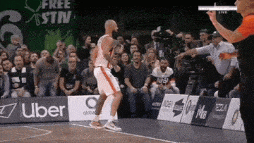 a basketball player is jumping in the air in front of an uber sign