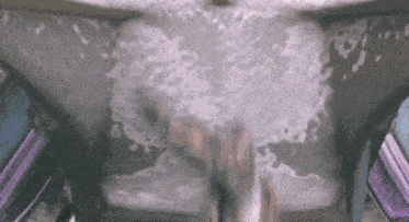 a person is standing in a bathtub with bubbles coming out of it ..