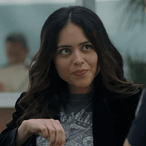 a woman wearing a black jacket and a t-shirt that says made in america