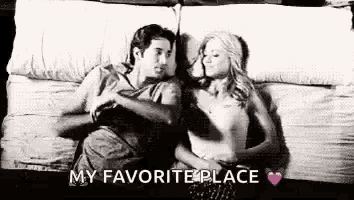a man and a woman are laying on a bed hugging and kissing .