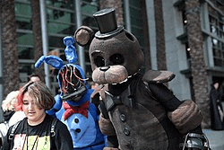a group of people dressed up as five nights at freddy 's characters are standing next to each other .