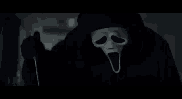 a person wearing a scream mask is holding a knife in their hand