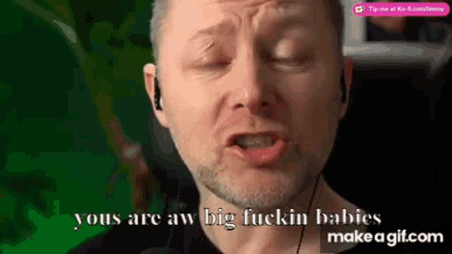 a man with a beard and ear buds says you 're aw big fuckin babies