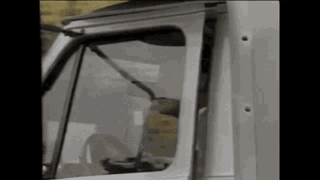 a man is driving a white truck with a bullet hole in the side of the window .