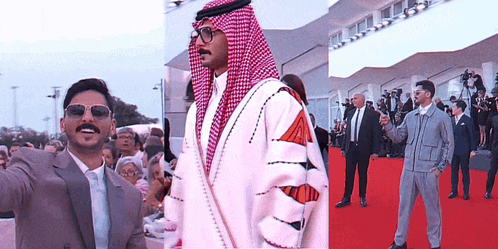 a man in a suit and sunglasses is standing on a red carpet with other men