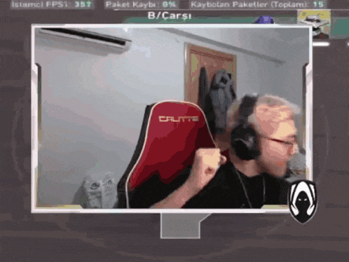 a man wearing headphones is sitting in a red crutte gaming chair