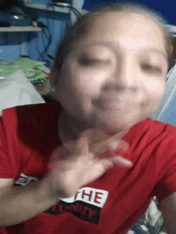 a person wearing a red shirt with the word unity on it .