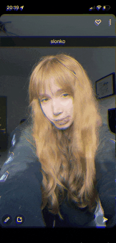 a girl with long blonde hair is taking a selfie on a phone with the name slonko on the screen