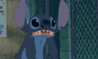 stitch from disney 's lilo and stitch is standing next to a chain link fence with his mouth open .