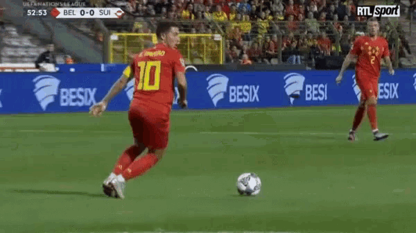 a soccer player with the number 10 on his jersey is dribbling the ball