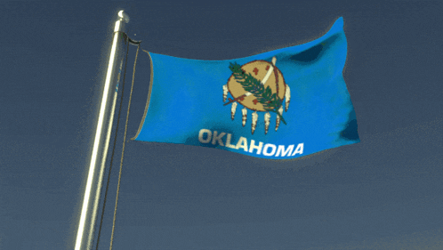 a blue oklahoma flag flies in the wind