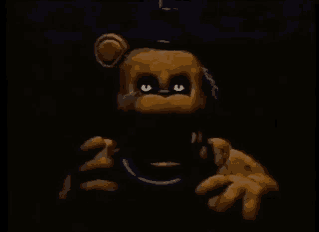 a teddy bear with glowing eyes is holding a purple necklace in the dark .