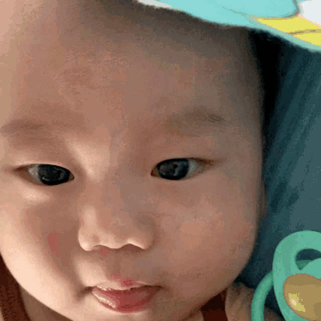 a close up of a baby 's face with a pacifier in front of it