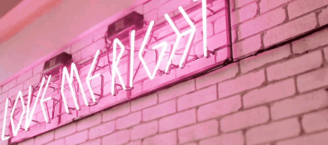 a pink neon sign on a white brick wall says " mangrigu "