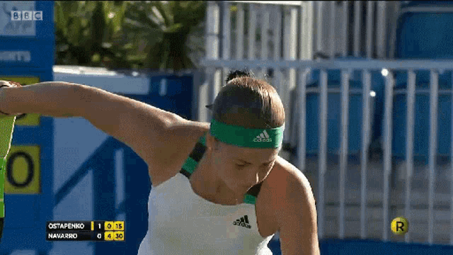 a tennis player wearing an adidas headband is playing a match
