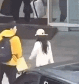 a man and a woman are walking down the street .
