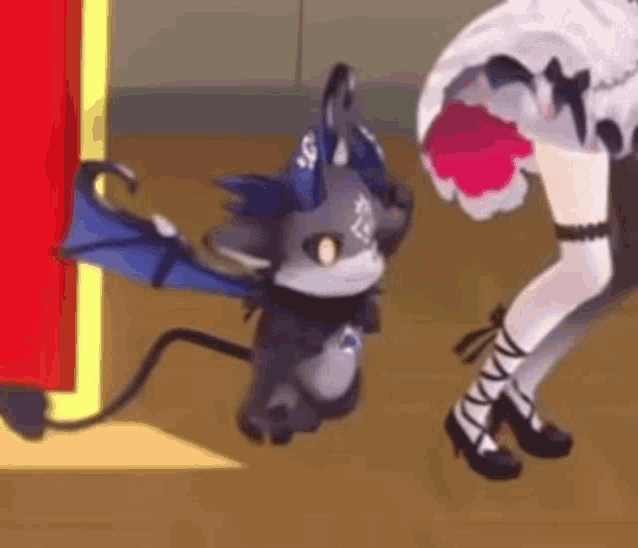 a cartoon cat with wings and horns is standing next to a woman in a dress .