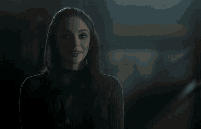 a woman in a dark room with the name ben levin on the bottom right
