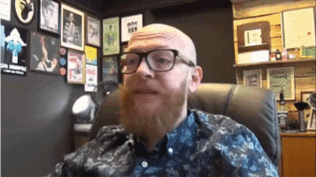 a man with a beard wearing glasses and a blue shirt