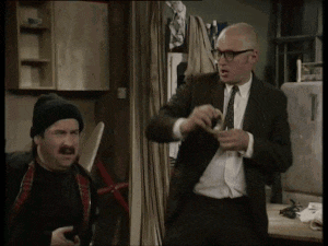 a bald man in a suit and tie stands next to another bald man