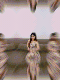a blurry picture of a woman in a dress standing in a room
