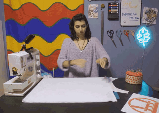 a woman cutting a piece of fabric in front of a pantheon pillow board