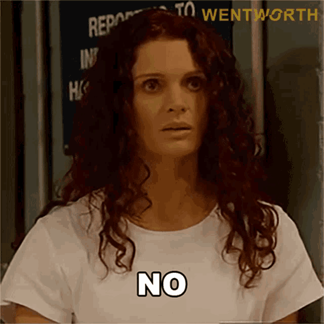 a woman with curly hair is wearing a white shirt with the word no on it
