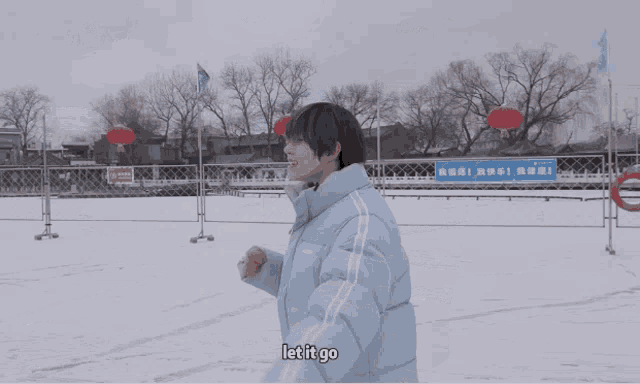 a person wearing a jacket that says nerdy stands in the snow with their arms outstretched