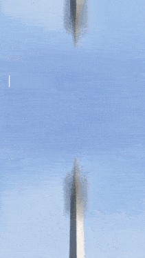 a blurry picture of a very tall building with a blue sky behind it