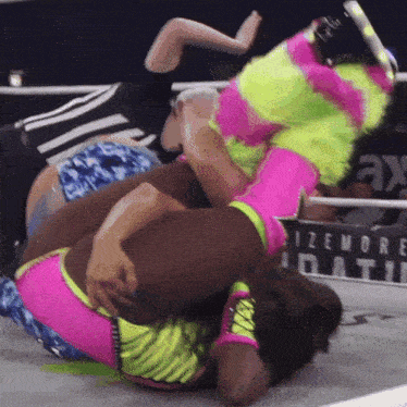two women wrestling in a ring with a sign that says izemore