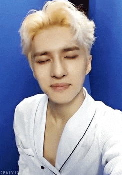 a young man taking a selfie with his eyes closed