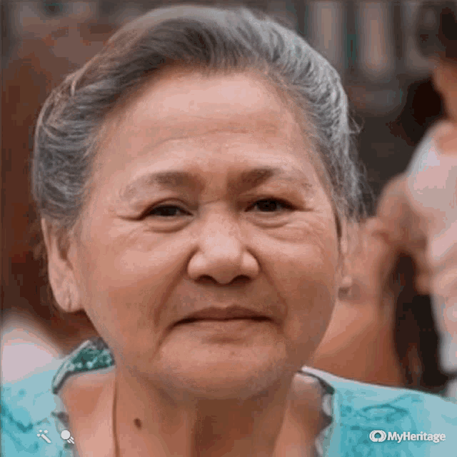 a close up of an elderly woman 's face with a myheritage logo on the bottom right