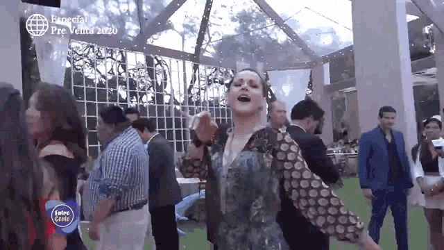 a woman is dancing in a crowd of people at a party