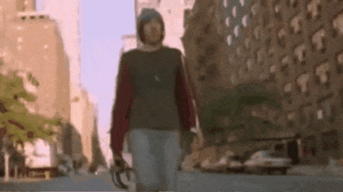 a blurry picture of a person walking down a street with buildings in the background