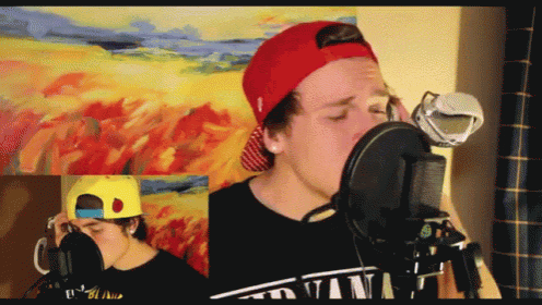 a man singing into a microphone wearing a red hat