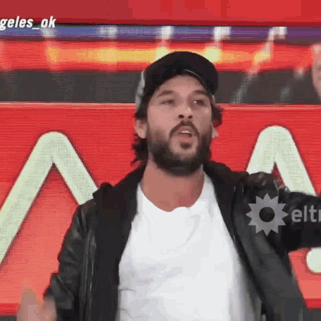 a man with a beard is standing in front of a sign that says angeles ok